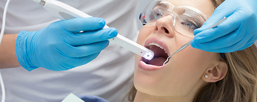 Dental assistant taking intraoral photos of patient's smile
