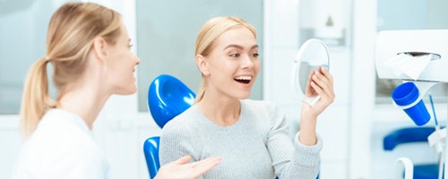 A woman admiring the results of cosmetic dentistry