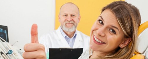 A woman at the dentist’s office showing a thumbs up