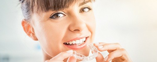 Woman placing Invisalign tray