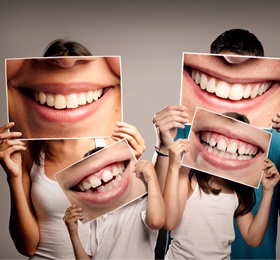 Family holding photos of smiles