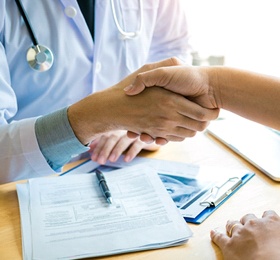 Dentist shaking hands with patient