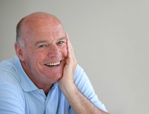 older man smiling blue shirt