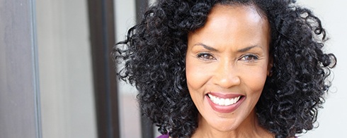 woman smiling after taking care of her dental implants in Mesquite