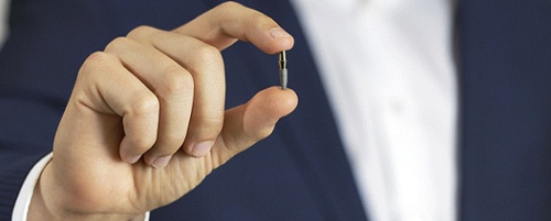 Man holding a dental implant in Mesquite