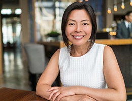 woman with dental implants in Mesquite sitting at a table