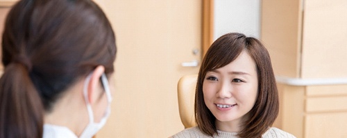 Young woman discussing with her dentist about a possible treatment she is pursuing