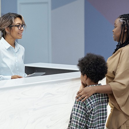 Mother and son talking to a receptionist