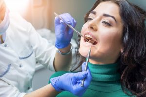 a woman having her teeth checked at the dentist’s office