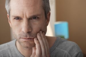 older man with toothache who needs emergency dentist