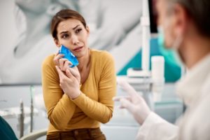 Woman talking to dentist about tooth pain