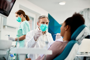 Dentist treating a patient during a checkup and cleaning