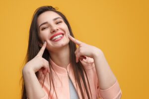 Smiling woman pointing to her mouth