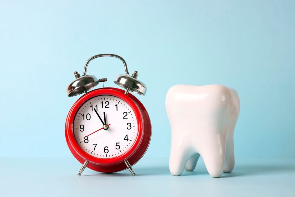 A ceramic tooth next to an alarm clock